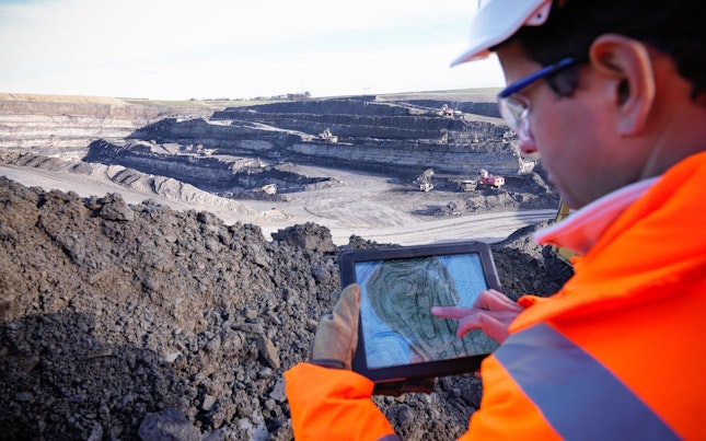 Engineer Using Digital Tablet Surveying Surface Coal Mine